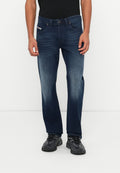 Dunkelblaue Jeans mit geradem Bein, dezentem Ausbleichen und einem Design mit fünf Taschen. Kombiniert mit schwarzen Sportschuhen.