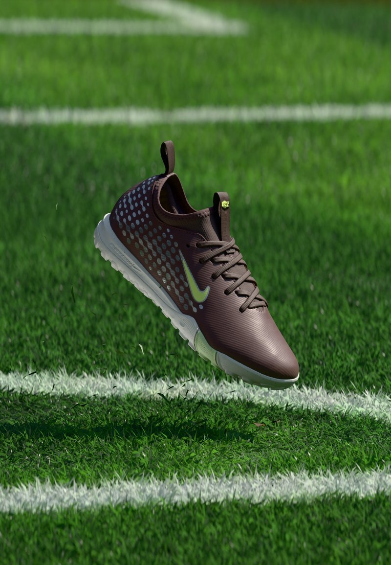 Dunkelbrauner Nike-Sneaker mit weißer Sohle und hellblauen Punkten, der über grünem Gras mit weißen Spielfeldlinien schwebt.