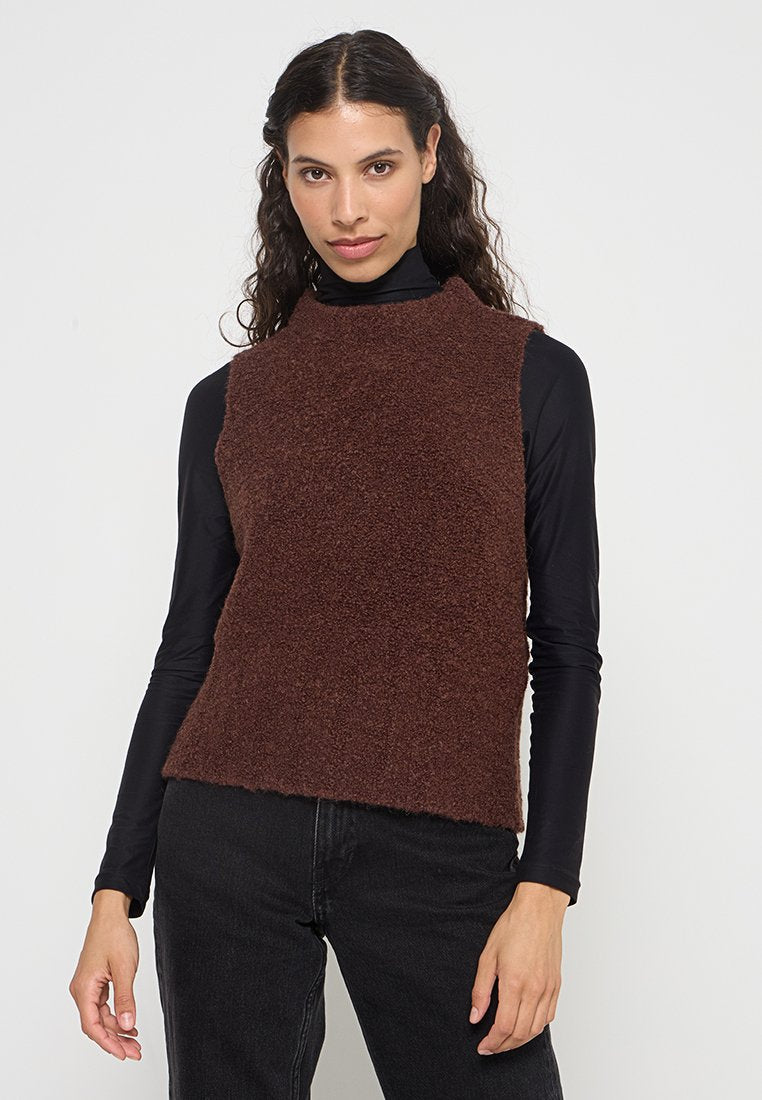 Brauner, kürzer geschnittener, flauschiger Strickpullover mit hohem Kragen, getragen über einem schwarzen Langarmoberteil; hat ein einfaches, strukturiertes Design.