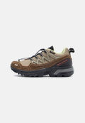 Trailrunning-Schuhe besitzen ein oberes Material aus braunem Wildleder und Mesh, eine schwarze Gummisohle, ein strukturiertes Schnürsystem und ein leuchtend grünes Innenfutter.