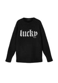 Schwarzer Pullover mit weicher Textur, der das Wort "lucky" in weißer, flauschiger Schrift auf der Vorderseite zeigt. Rundhalsausschnitt und lange Ärmel.