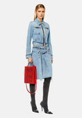 Hellblaue Jeansjacke und Rock im Set, mit einem verkürzten Design, kombiniert mit einer roten Diesel-Tasche und dunkelgrauen kniehohen Stiefeln.