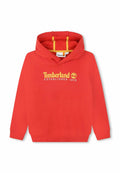 Roter Baumwollkapuzenpullover mit einem gelben Timberland-Logo und dem Text "ESTABLISHED 1973" sowie einer kontrastierenden gelben Innenseite der Kapuze.