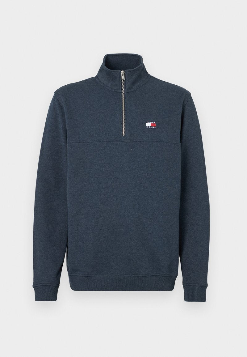 Dunkelblaues Sweatshirt mit einem hohen Kragen, halbem Reißverschluss vorne und elastischen Bündchen. Mit einem kleinen Logo-Patch auf der oberen linken Brust. Weicher Stoff.