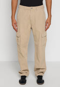 Khaki Cargo-Hosen aus strapazierfähigem Stoff, mit zwei seitlichen Taschen, einer lässigen Passform und einem Knopfverschluss. Getragen mit schwarzen Sportschuhen.