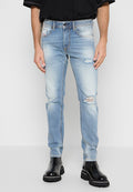 Helle blaue Jeans mit abgeriebenen Details, schmaler Schnitt und Fünf-Taschen-Design. Getragen mit schwarzen Chelsea-Stiefeln mit dicker Sohle.