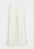 Weite Sweatpants in Creme mit einer weichen Textur, versehen mit schwarzen Seitenstreifen und einem elastischen Bund für Komfort und ein angenehmes Tragegefühl.