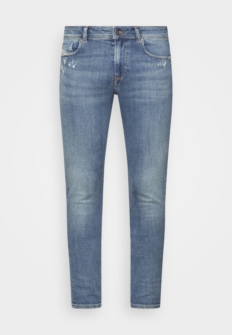 Hellblaue Denim-Jeans im Slim-Fit, mit dezenten Ausbleichungen, Vorderpockets, einem Reißverschluss und minimalen Gebrauchsspuren auf dem Stoff.