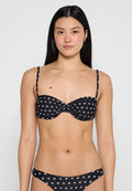 Schwarzer Bikini-Oberteil mit weißem Blumenmuster, verstellbaren Trägern, Raffung in der Mitte, passendem Unterteil, glattem Stoff und minimaler Abdeckung.