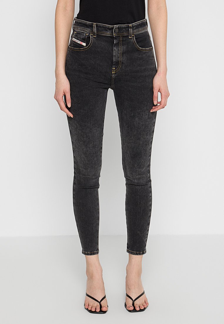 Schwarze Jeans im Skinny-Fit aus Denim mit gelben Nähten und fünf Taschen. Hohe Taille, leicht verblasste Textur und taillierte Silhouette.