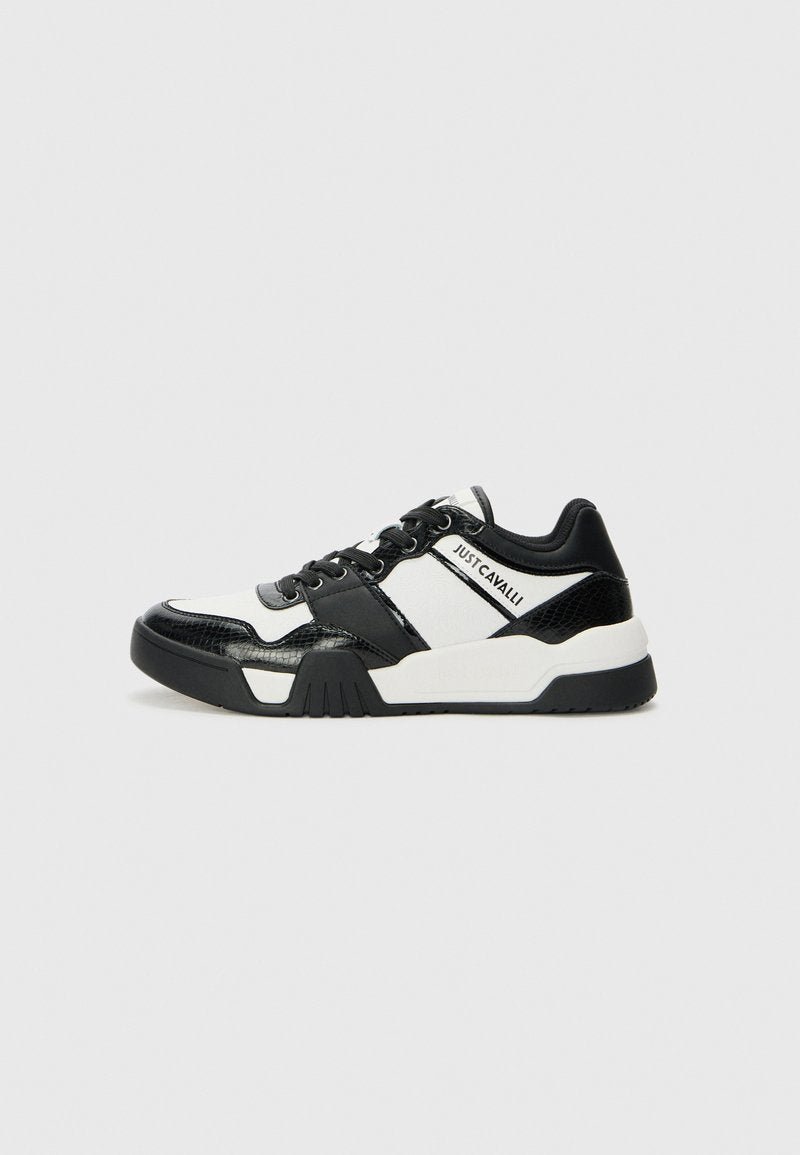Schwarz-weiße Turnschuhe mit einem strukturierten Obermaterial aus schwarzem Lackleder, weißen Akzenten, runder Zehenpartie und einer robusten Gummisohle.