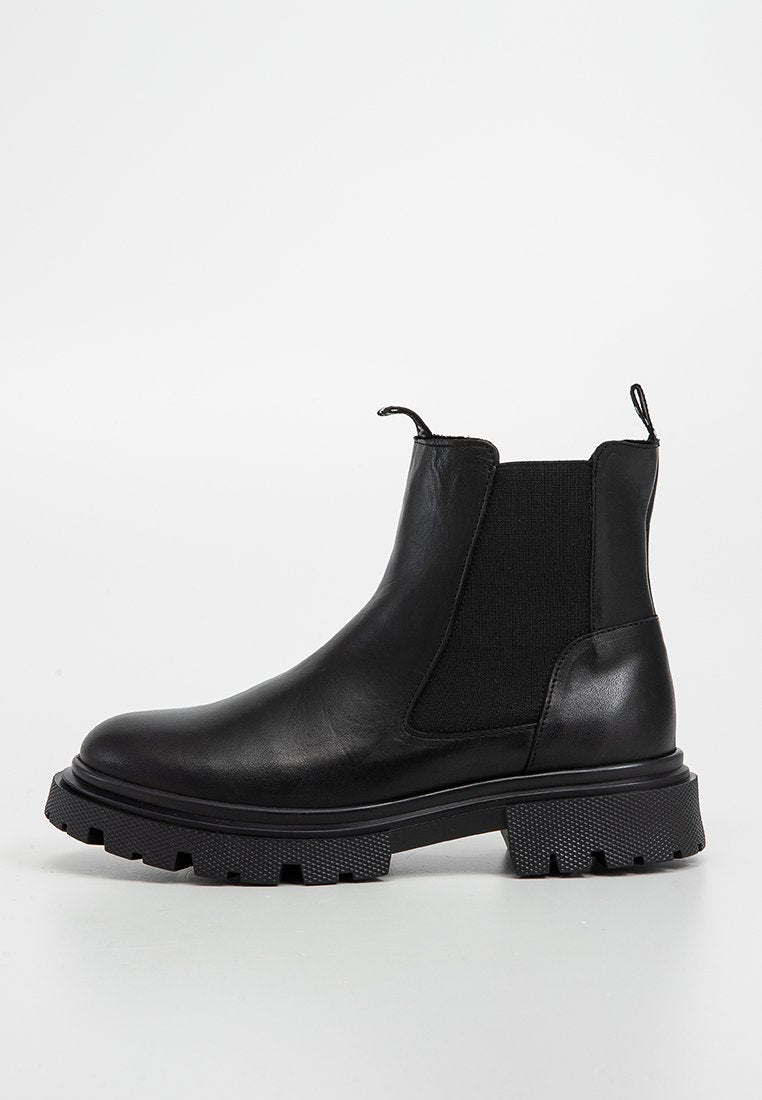 Schwarze Leder-Ankle-Boots mit strukturierten elastischen Seitenpaneelen, Zuglasche und derben schwarzen Gummisohlen. Glatte Oberfläche mit lässigem, robustem Design.