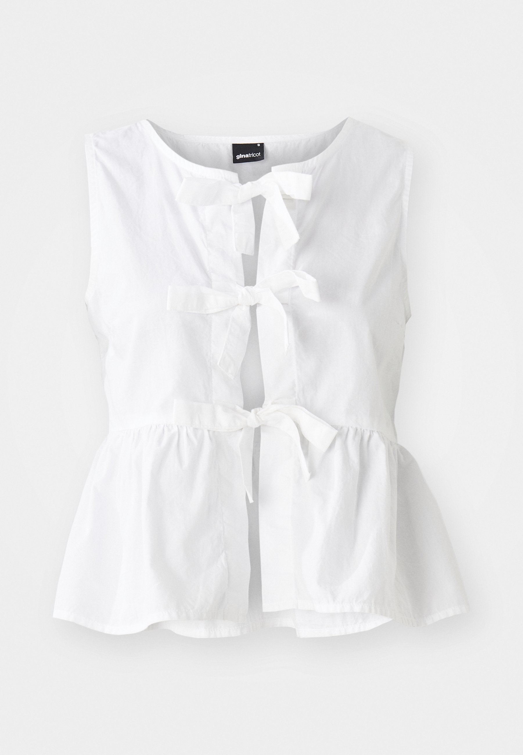 Weißes ärmelloses Oberteil aus leichtem Material, mit Peplum-Saum, vorderen Bindebändern und Schlüssellochöffnung, sowie einem runden Ausschnitt.