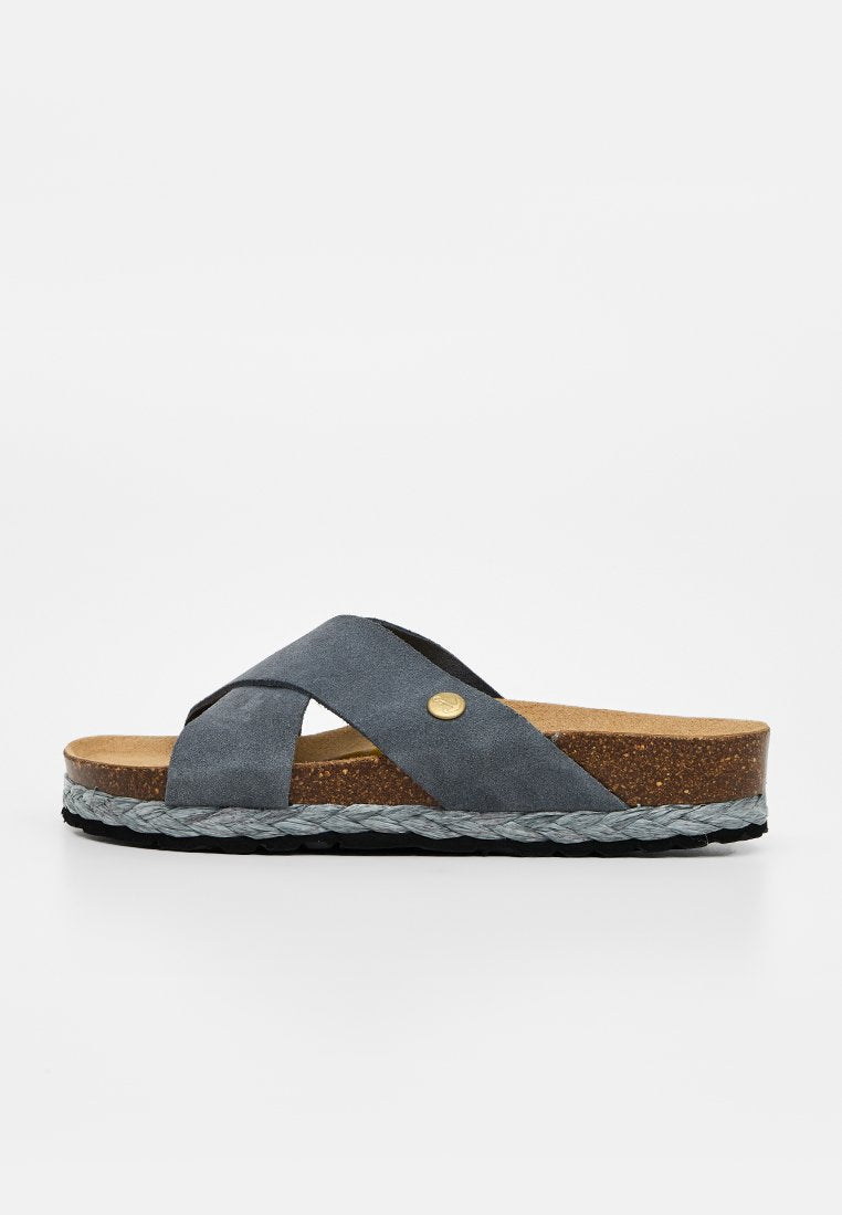 Blauer Wildleder-Slide-Sandalette mit überkreuzten Riemen, Kork-Fußbett, geflochtenem Mittelfußsohlen-Detail und schwarzer strukturierter Laufsohle.