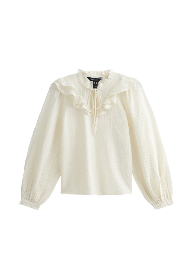 Weiße Bluse mit langen Ärmeln, rüschigem Ausschnitt und weicher Textur; verfügt über eine Schleife am Kragen und geraffte Puffärmel.