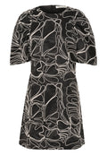 Kurzes schwarzes Kleid mit puffartigen Ärmeln und einem strukturierten Stoff, der komplexe weiße Blumemuster aufweist.