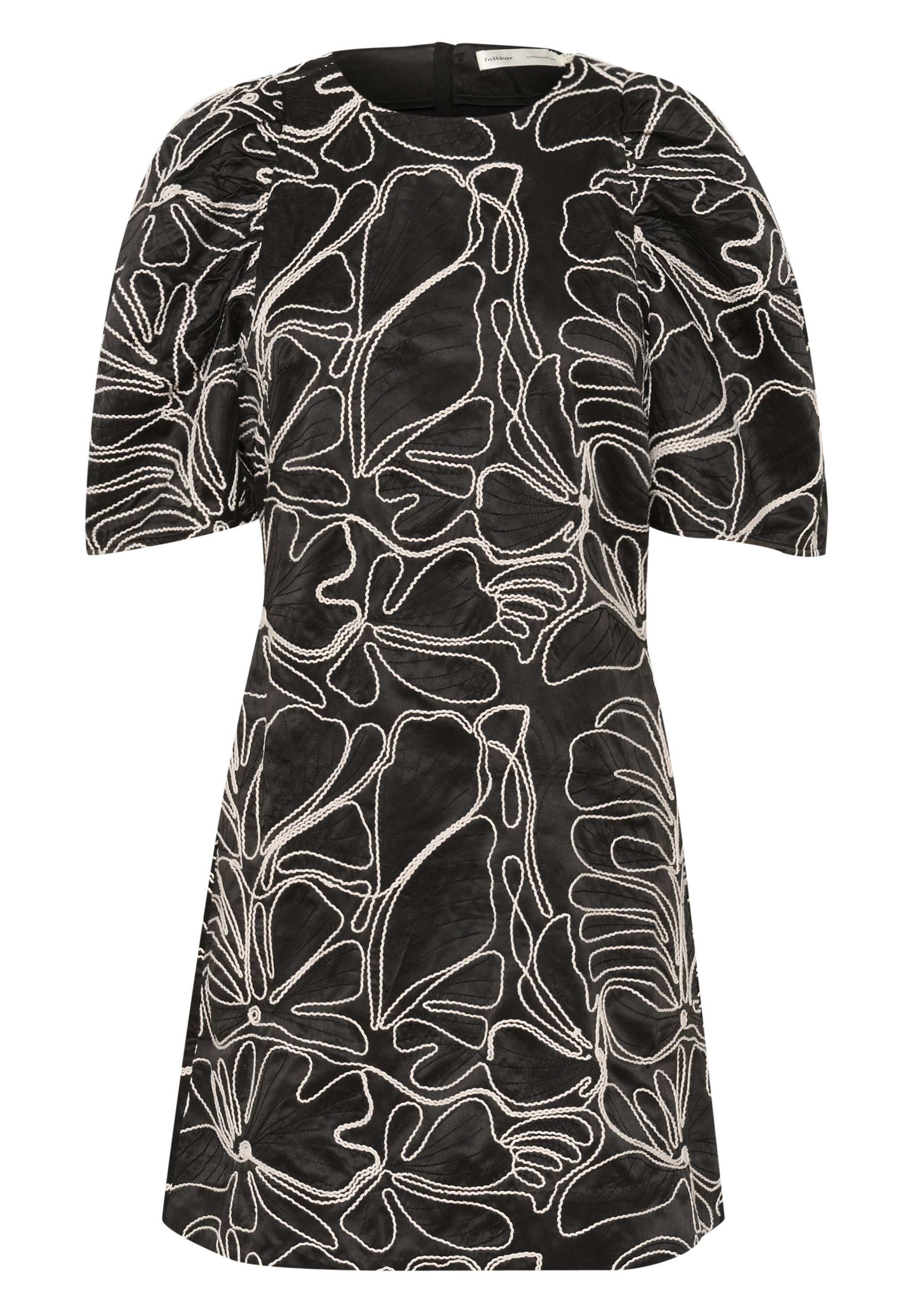 Kurzes schwarzes Kleid mit puffartigen Ärmeln und einem strukturierten Stoff, der komplexe weiße Blumemuster aufweist.
