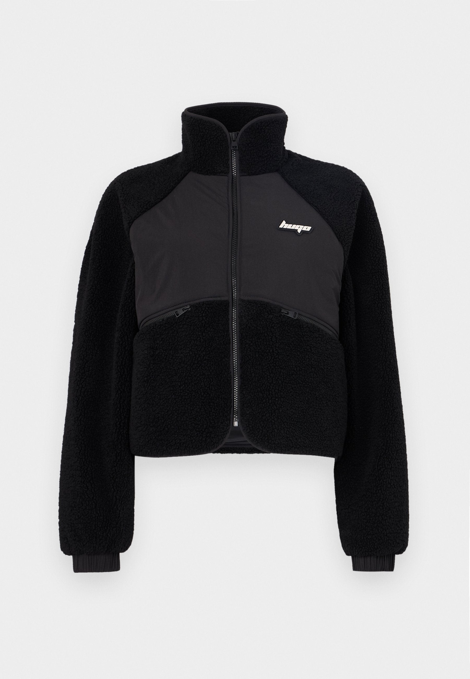 Schwarze Zip-Jacke mit Fleece- und glatten Stoffpaneelen, hohem Kragen und gerippten Bündchen. Mit Logo auf der Brust und vorderen Reißverschlusstaschen.
