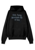 Schwarzer Hoodie mit einer Kängurutasche. Aufgedruckter Schriftzug in hellblau mit der Aufschrift "Dieses Lied erinnert mich an dich" in einer stilisierten Schriftart.