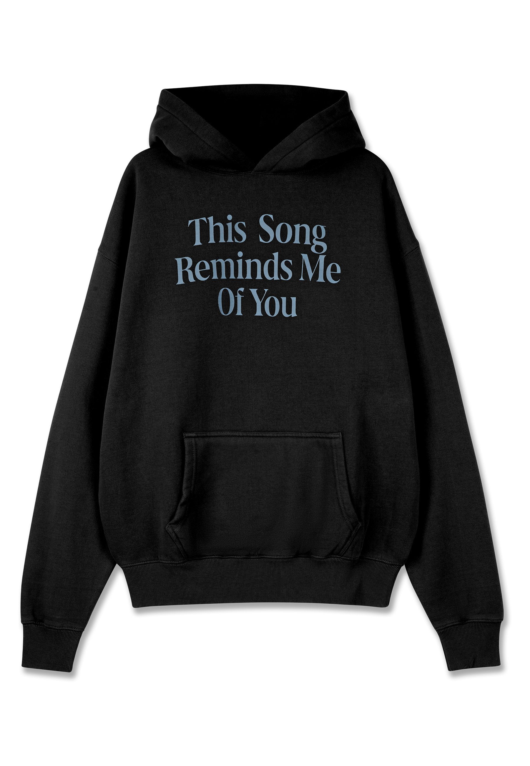 Schwarzer Hoodie mit einer Kängurutasche. Aufgedruckter Schriftzug in hellblau mit der Aufschrift "Dieses Lied erinnert mich an dich" in einer stilisierten Schriftart.