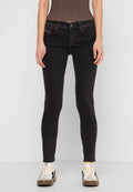 Schwarze schmale Jeans aus Denim, mit einem klassischen Fünf-Taschen-Design und dezenten Nähdetails. Kombiniert mit lässigen Sneakers.