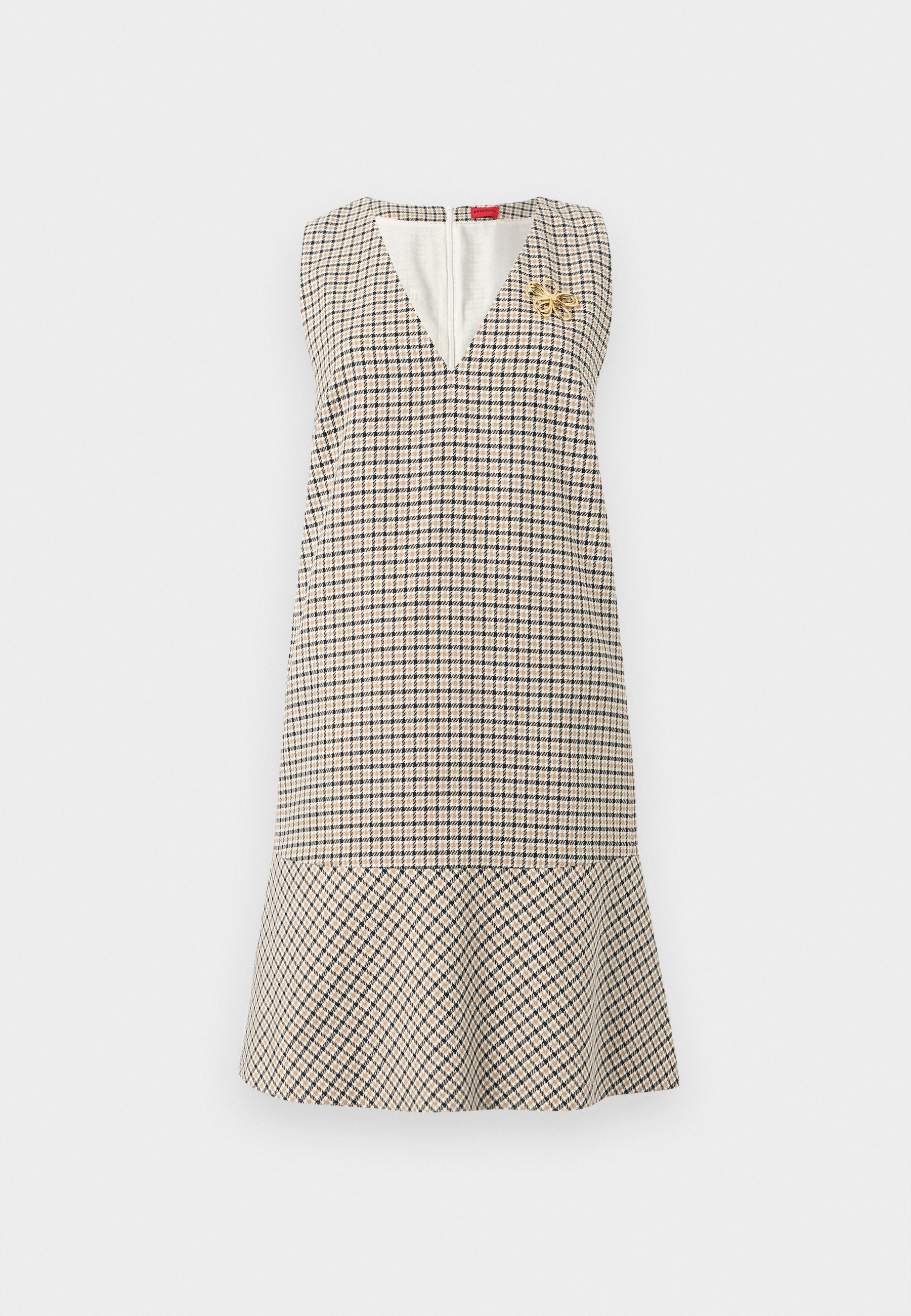Ärmelloses, beige-schwarz kariertes Kleid mit tiefem V-Ausschnitt und gerafftem Saum, verziert mit einer kleinen goldenen Schmetterlingsbrosche auf der linken Brust.