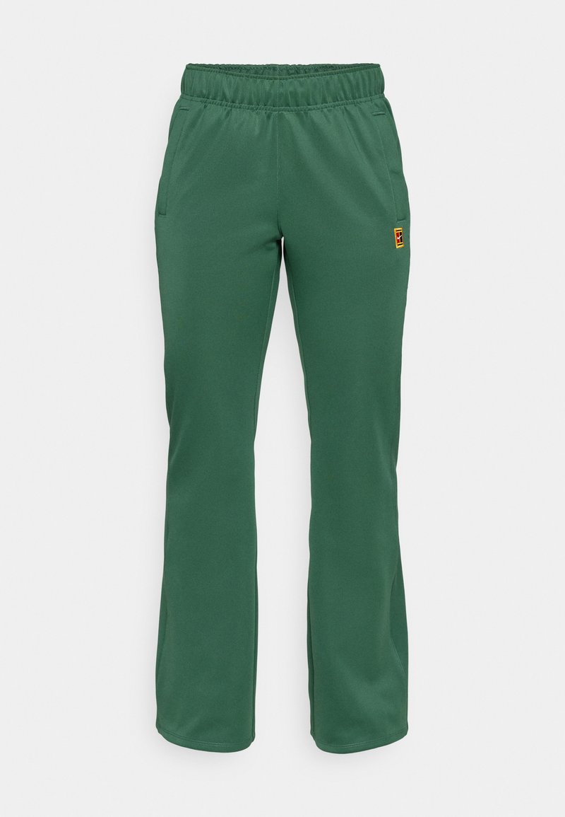 Grüne Sporthose mit einem elastischen Bund, zwei seitlichen Taschen und einem schlanken Schnitt. Hergestellt aus weichem Material mit feiner Textur.