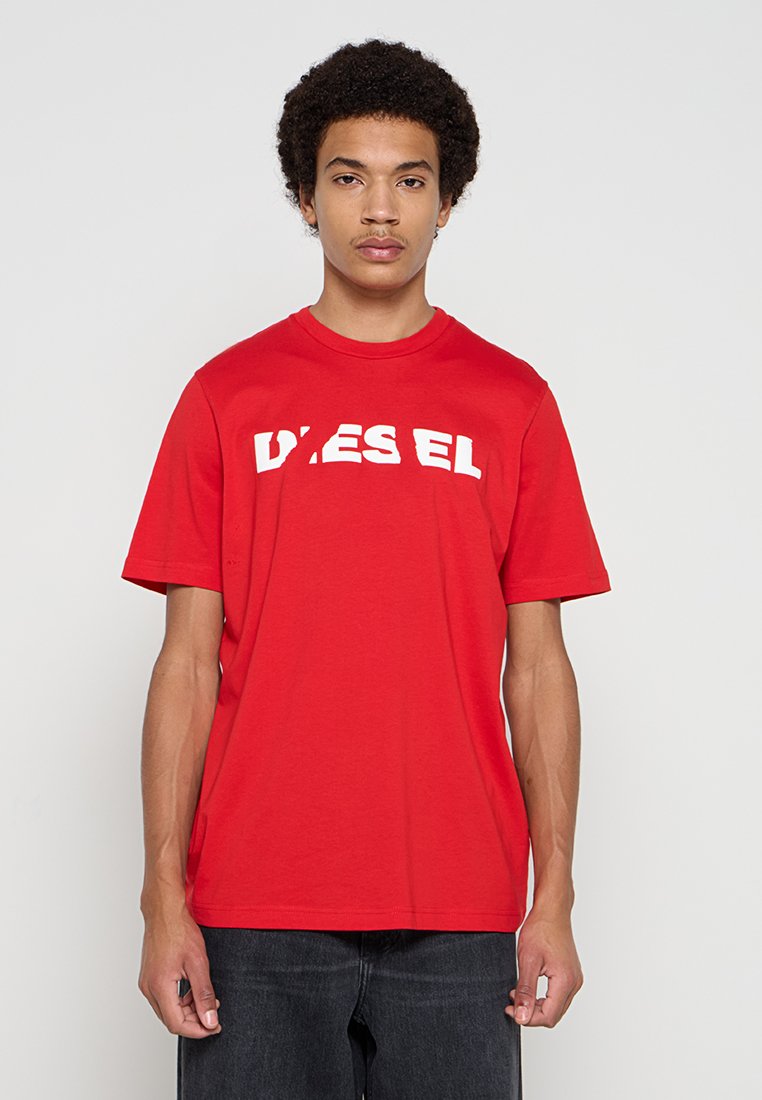 Rotes Baumwoll-T-Shirt mit einem weißen Blocklogo mittig auf der Brust. Klassischer Rundhalsausschnitt und kurze Ärmel. Einfaches, unverziertes Design.
