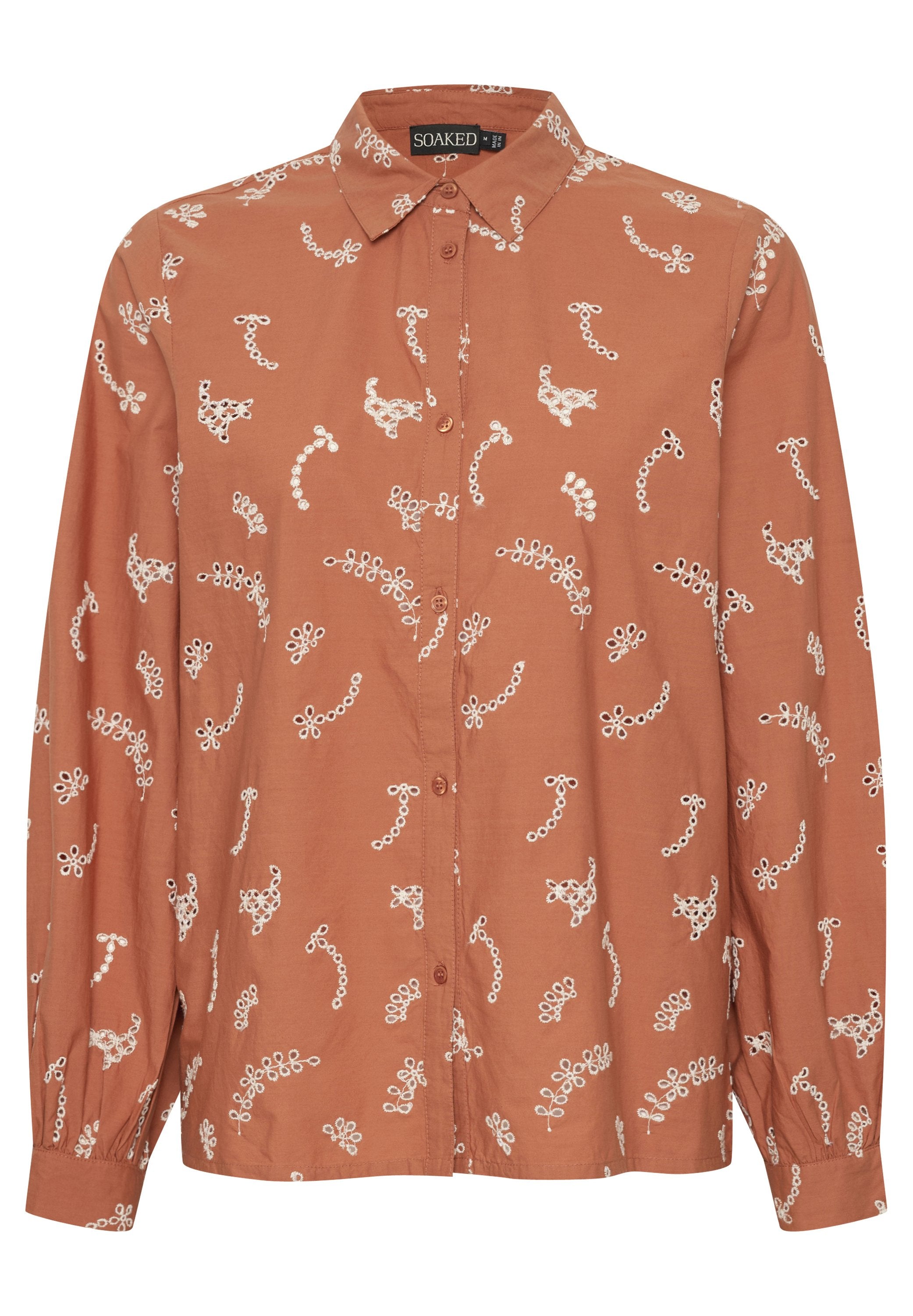 Eisenorange Langarm-Bluse mit Knopfleiste und weißen gestickten abstrakten Blumenmustern sowie einem spitzen Kragen.