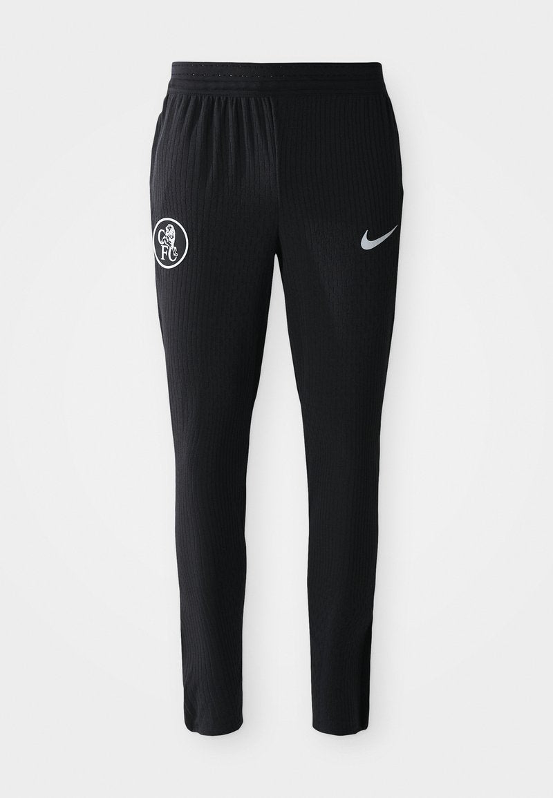 Schwarze Sporthosen mit gerippter Textur, auf der linken Hose mit einem weißen FC-Logo und auf der rechten Seite mit einem grauen Nike-Swoosh.