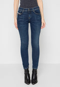 Schmale Jeans aus dunkelblauem Denim mit fünf Taschen, genähten Details und Reißverschluss. Kombiniert mit schwarzen Ankle Boots mit hohen Absätzen.