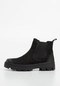 Schwarze Ankle Boots aus Wildleder mit einem elastischen Seitenpanel, abgerundetem Zeh und einer strukturierten Gummisohle, die tiefe Rillen für besseren Halt aufweist.
