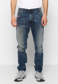 Ausgeblichene Jeans in Blau mit geradem Beinschnitt, die subtile Abnutzungsspuren, fünf Taschen und kontrastierende Nähte aufweisen. Getragen mit grauen Sneakers.