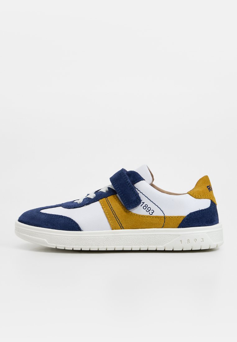 Weißer Sneaker mit marineblauen und senfgelben Wildlederakzenten, Klettverschluss und der Aufschrift "1893" an der Seite und Sohle.