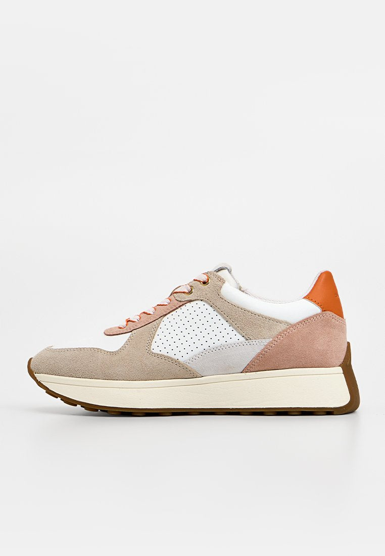 Beige-weißer Wildledersneaker mit perforierter Seitenlasche, orangefarbenem Fersenlaschenband, cremefarbener Sohle und Schnürsenkeln mit orangefarbenen Akzenten, Seitenansicht auf weißem Hintergrund.