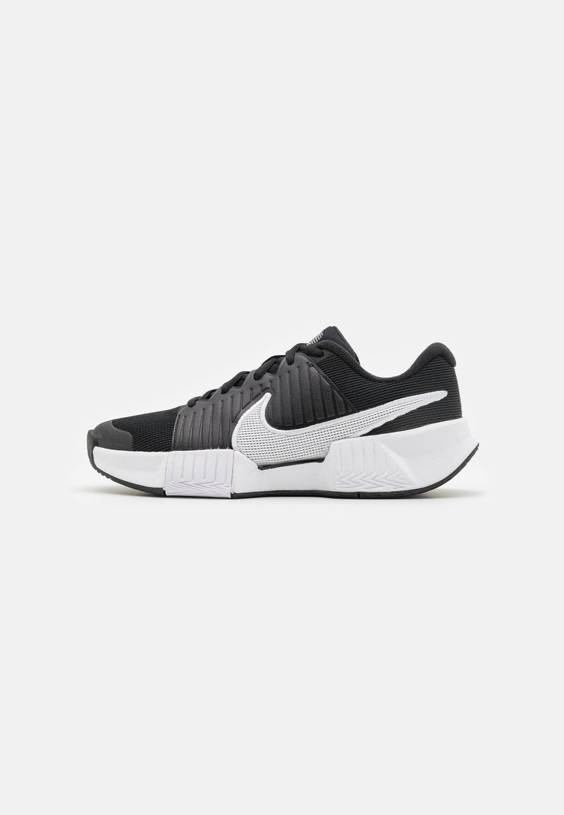 Schwarz-weiße Sportschuhe mit einer strukturierten Oberseite, einem auffälligen Nike-Logo und einem kontrastierenden Sohlen-Design für besseren Halt und Stabilität.