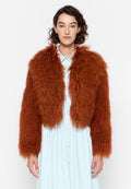 Gekürzte Jacke aus lockigem braun-orangefarbenem Kunstfell mit langen Ärmeln. Trägt man über einem hellblauen Hemdkleid mit rundem Kragen und Knöpfen.