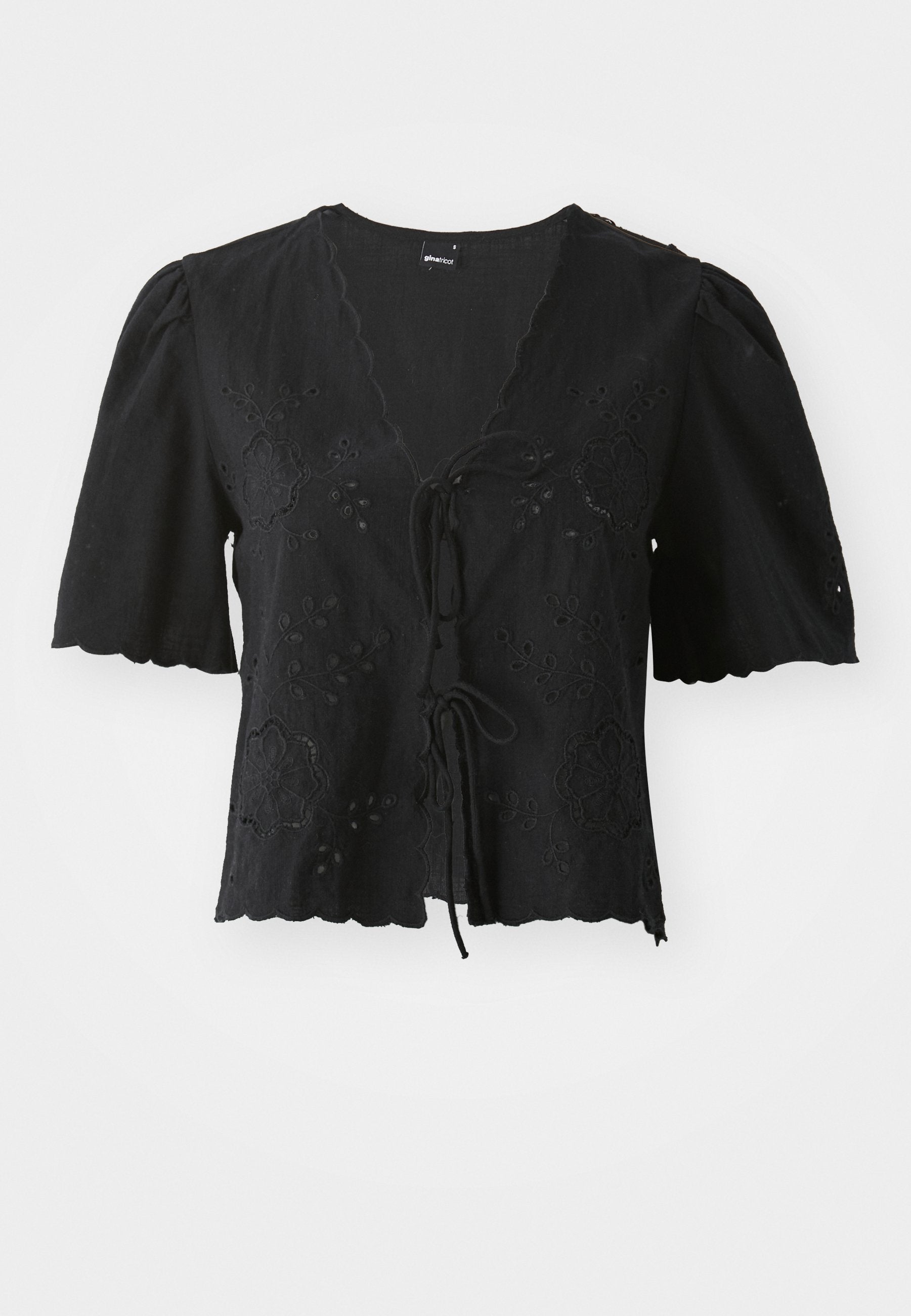 Schwarze kurzärmelige Bluse aus leichtem Stoff, mit floralen Stickereien, einem V-Ausschnitt und Knotenverschluss auf der Vorderseite. Wellenförmiger Saum.