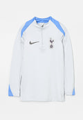 Hellgraues langärmliges Sportoberteil mit hellblauen Schulterakzenten, Viertel-Reißverschluss, schwarzem Nike-Logo und Emblem des Fußballclubs Tottenham Hotspur.