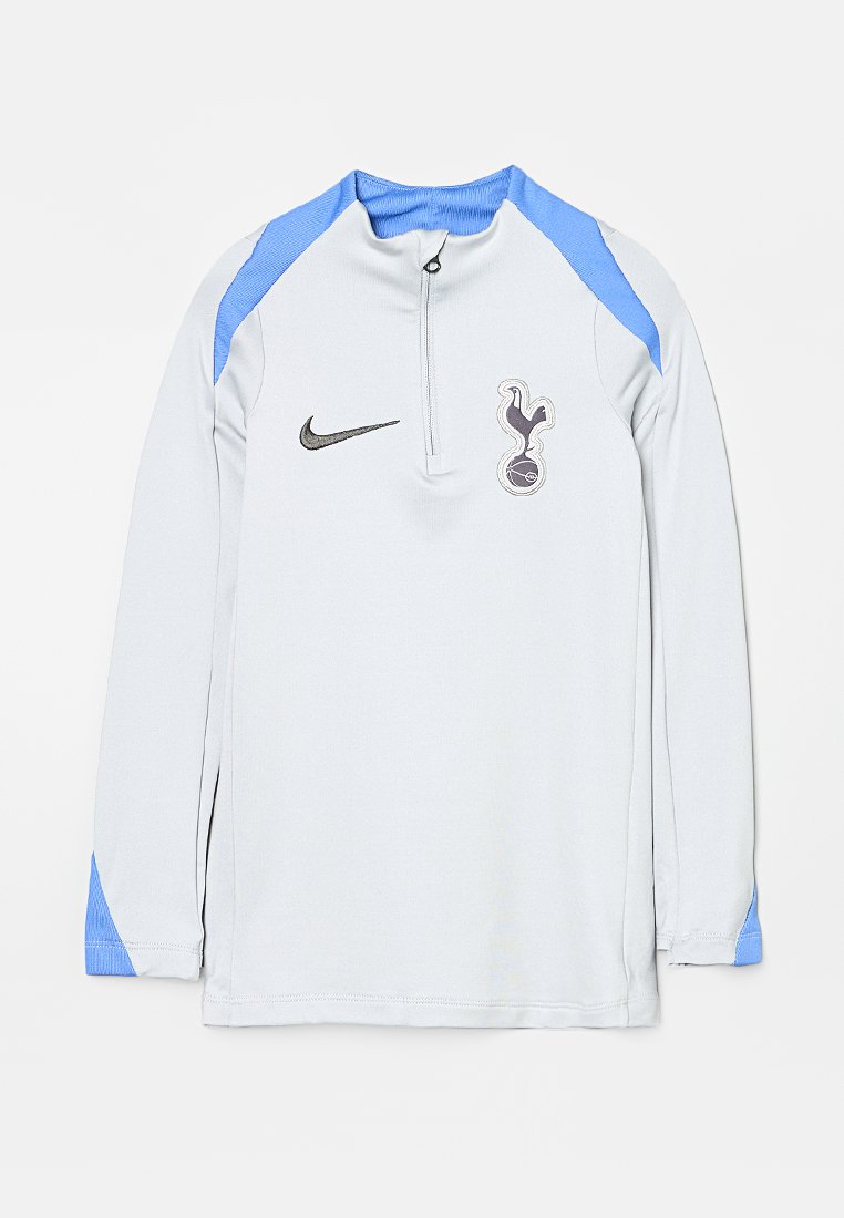 Hellgraues langärmliges Sportoberteil mit hellblauen Schulterakzenten, Viertel-Reißverschluss, schwarzem Nike-Logo und Emblem des Fußballclubs Tottenham Hotspur.