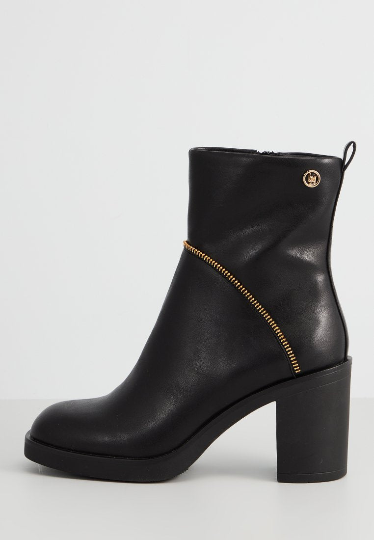 Schwarze Leder-Stiefelette mit einem dicken Absatz, ausgestattet mit einem goldenen Reißverschluss und einem kreisförmigen Logo. Glatte Textur mit einer eleganten Silhouette.