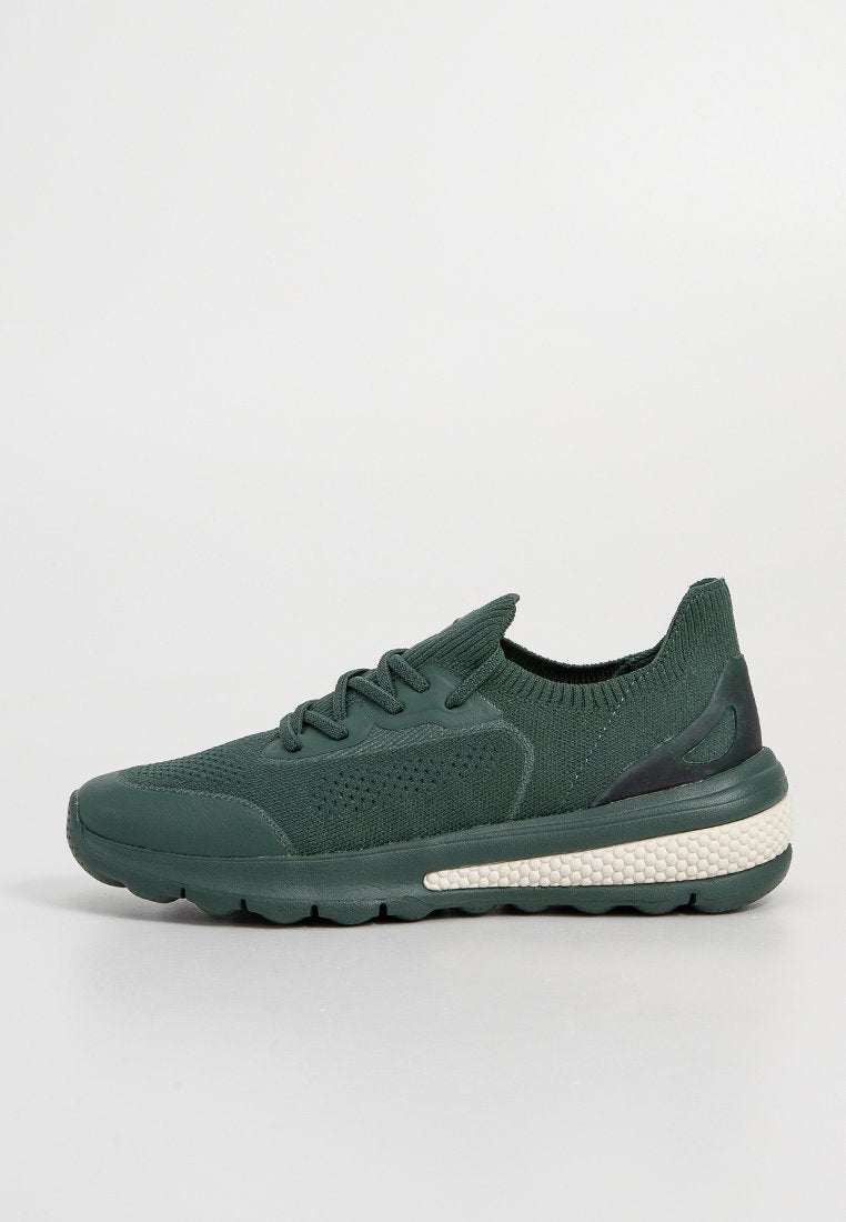 Grüne Strick-Sneaker mit einer strukturierten Oberfläche, runder Spitze und schwarzem Fersenakzent. Gerillte Sohle mit einem cremefarbenen Zwischensohlen-Detail.
