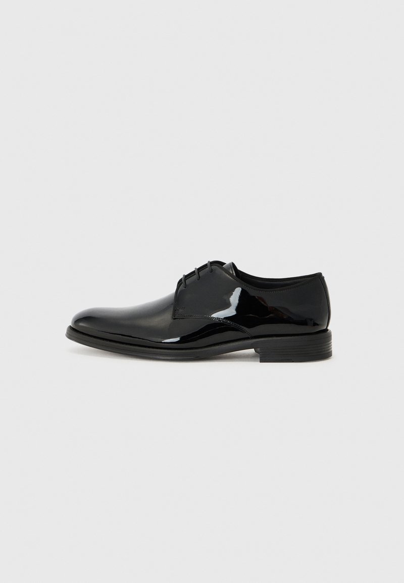 Schwarze Dressschuhe mit einem glänzenden Lackleder-Finish, runder Zehenform und externen Nähten. Sie verfügen über einen niedrigen Absatz und eine Schnürung.