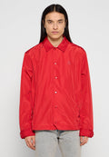Rote, leichte, wasserdichte Jacke mit Kragen, Druckknöpfen und einem kleinen Logo auf der Brust. Sie hat lange Ärmel und einen lässigen Schnitt.