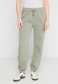 Helle olivgrüne Jogginghose aus weichem Material, mit einem elastischen Bund mit Kordelzug, seitlichen Taschen und ribbeligen Säumen.