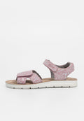 Rosa Stoffsandalen mit Blumenmuster, zwei verstellbaren Riemen und einem strukturierten Fußbett. Die Sohle ist weiß und hat ein flaches Design.