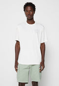 Mann trägt ein weißes O'Neill T-Shirt mit kurzen Ärmeln und hellgrüne Cargo-Shorts und steht vor einem schlichten Hintergrund.