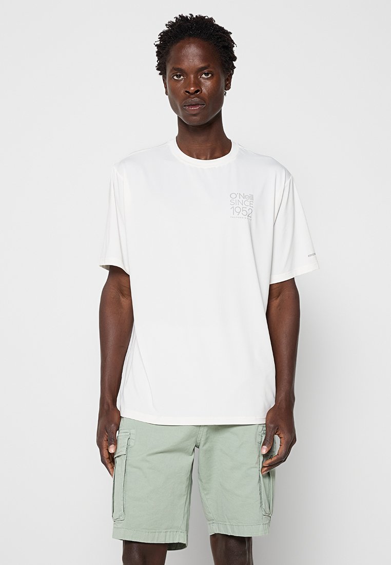 Mann trägt ein weißes O'Neill T-Shirt mit kurzen Ärmeln und hellgrüne Cargo-Shorts und steht vor einem schlichten Hintergrund.