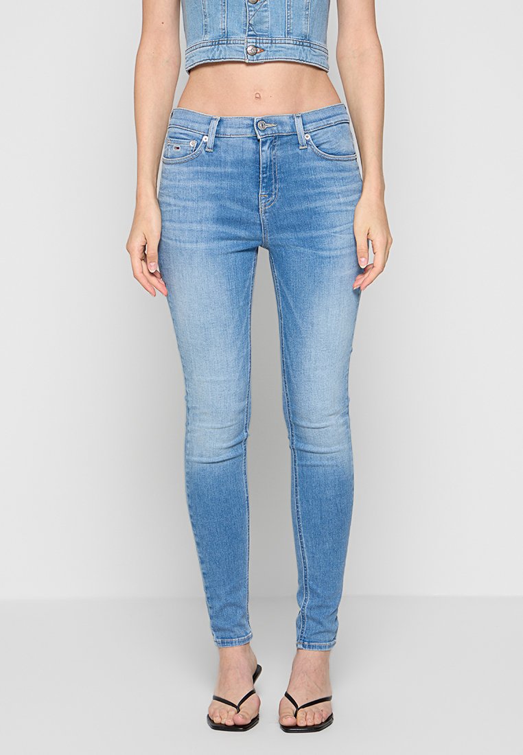 Himmelblaue, figurbetonende Jeans aus Denim. Merkmale sind eine mittelhohe Taille, fünf Taschen und ausgewaschene Akzente. Glatte Textur über die gesamte Fläche.