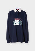 Marineblaues Polohemd mit langen Ärmeln und weißem Kragen. Mit einem grafischen Druck von "TOMMY" und "Registered Trademark New York City" in kontrastierenden Farben.